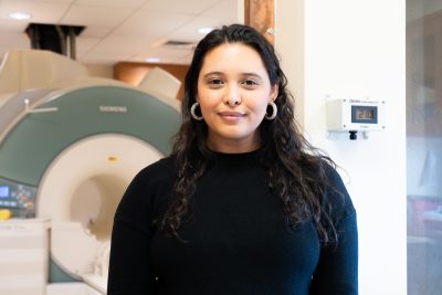 Blakely Lockhart standing in front of a magnetic resonance imaging scanner